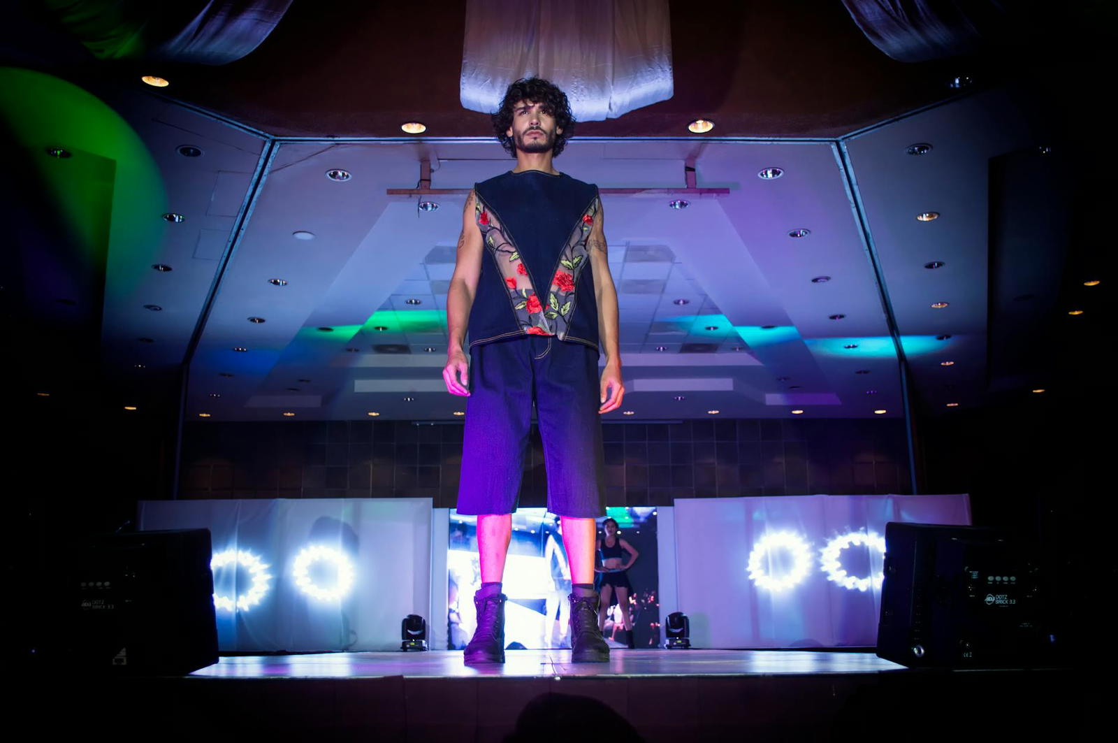 man in blue top and bottoms standing on stage