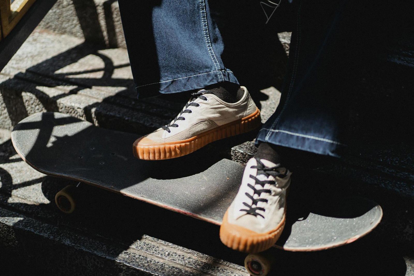 crop unrecognizable male sitting on stairway with feet on skateboard