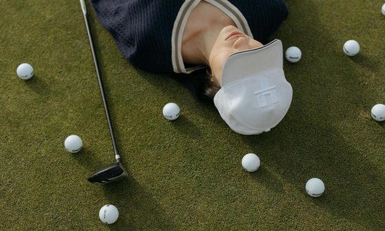 woman wearing a white cap lying on the ground