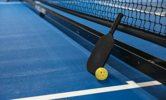 ping pong paddle and ball next to net