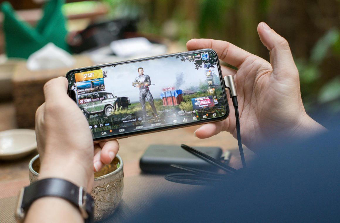 person holding a smartphone playing mobile game