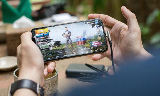 person holding a smartphone playing mobile game